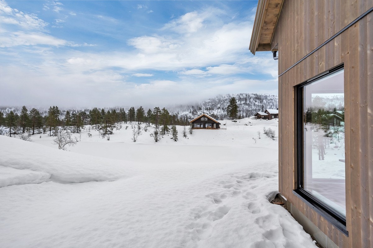 Hytta ligger fritt og fint med tjernet foran Galleribilde