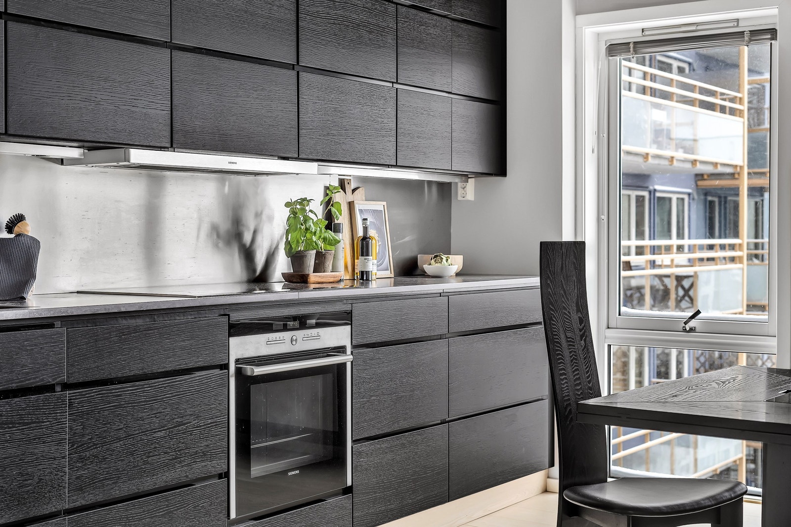 Benkeplate av steinkompositt. Integrert i innredningen er oppvaskmaskin, ovn, induksjon platetopp og kjøl/frys. Galleribilde