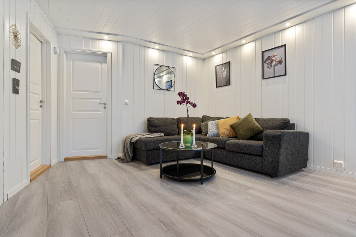 Romslig stue med naturlige soner for møblering som sofagruppe og spisebord.
