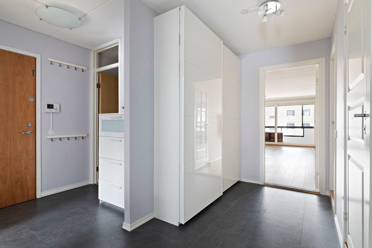 Romslig entré med god oppbevaringsplass i stor skyvedørsgarderobe. Galleribilde