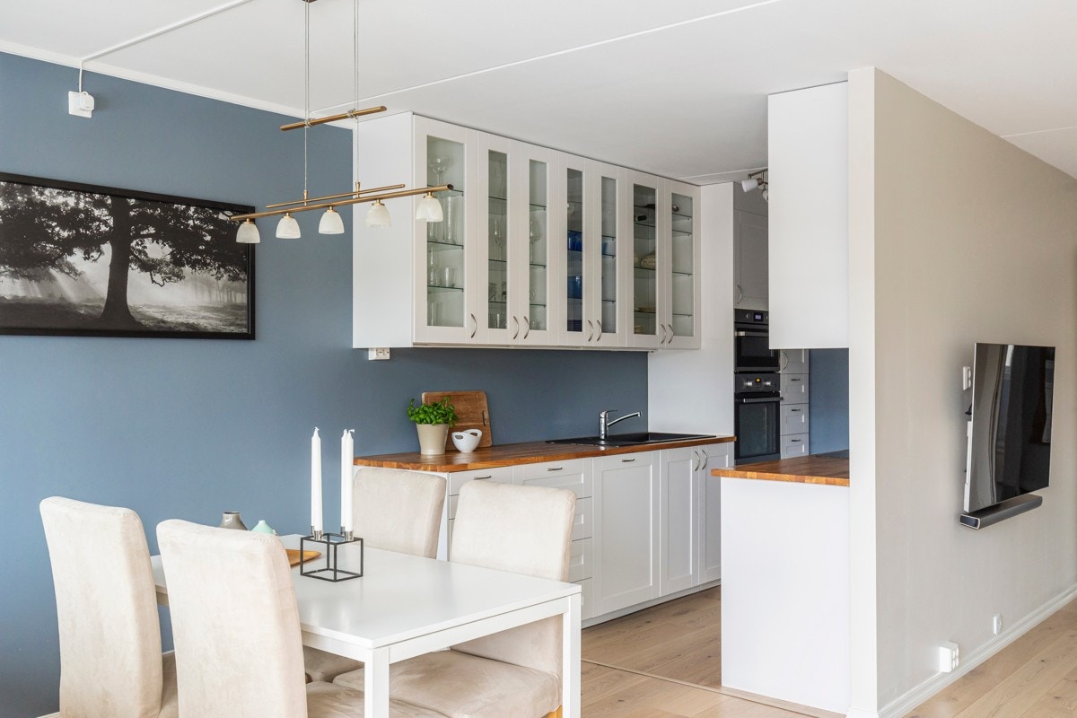 Kjøkkenet er fra Ikea med hvite profilerte fronter og vitrineskap med belysning. Galleribilde