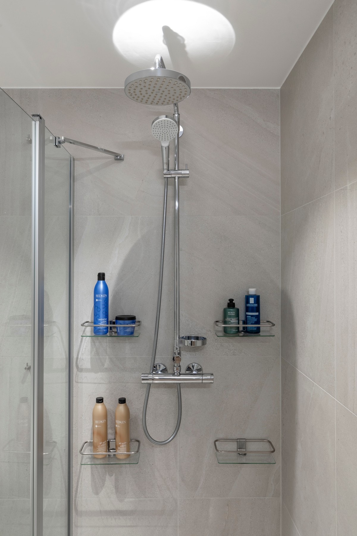 Dusjhjørne med nedsenket gulv, innfellbare glassdører og Damixa armatur med regnfalls- og hånddusj. Galleribilde