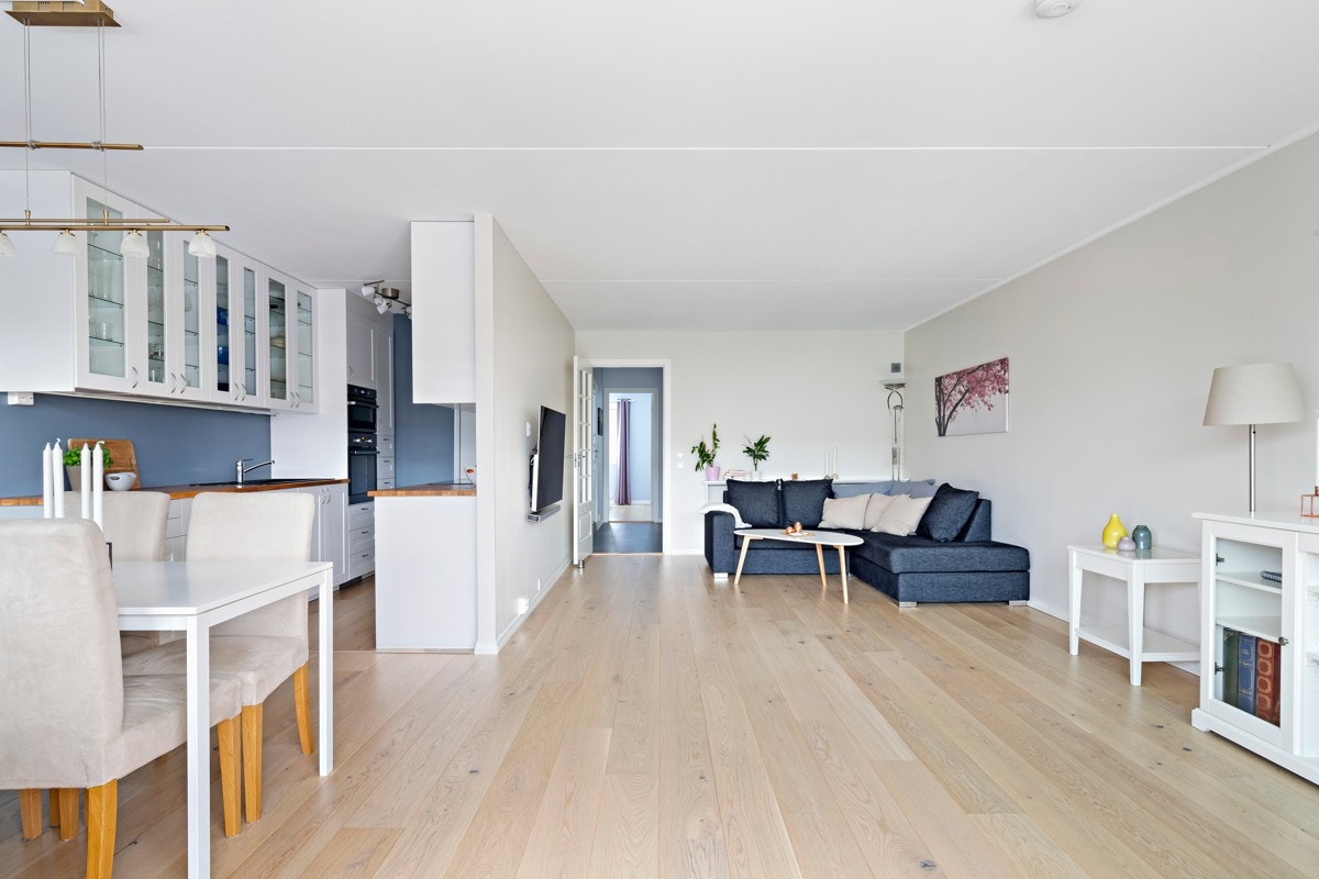 Kjøkken og stue/spisestue ligger i delvis åpen løsning for en sosial og livlig leilighet. Galleribilde