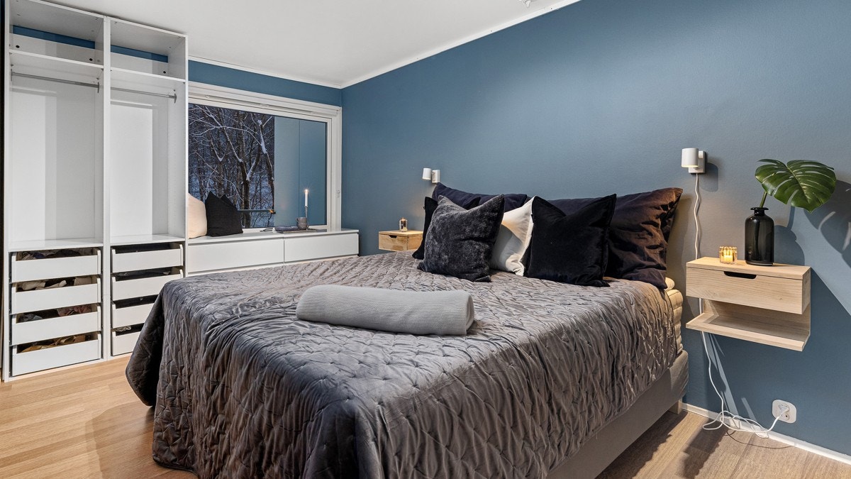 Hovedsoverommet fremstår som luftig med god plass til dobbeltseng, nattbord og kommode Galleribilde