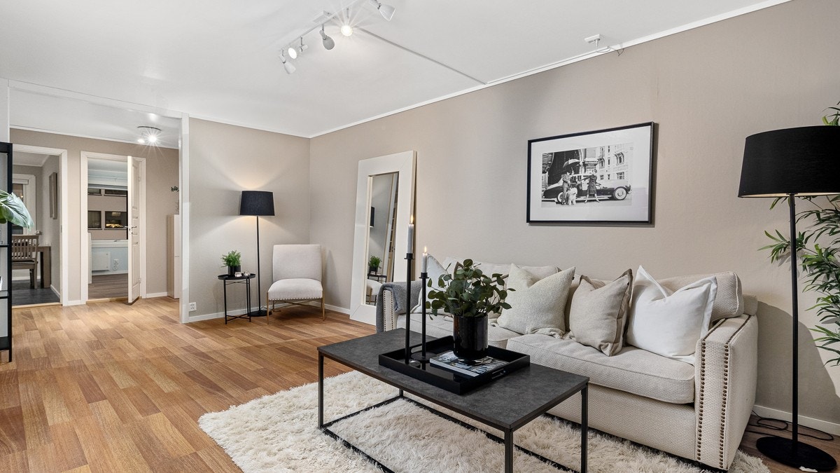 Delikate fargevalg gir stuen et stilrent preg, og det lune laminatgulvet harmonerer fint med den varme beigetonen på veggene som sørger for et helhetlig og harmonisk uttrykk Galleribilde