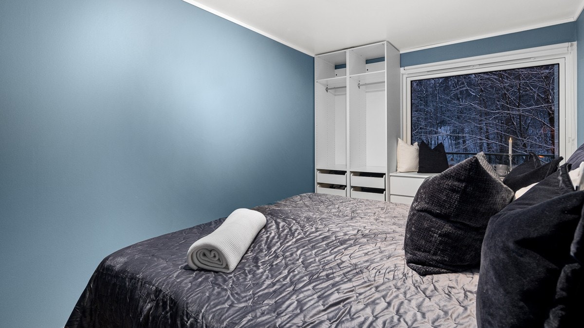 Rommet er malt i en behagelig og dyp blåtone som gir rommet en rolig og innbydende atmosfære Galleribilde