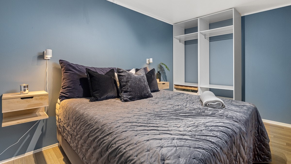 Rommet er malt i en behagelig og dyp blåtone som gir rommet en rolig og innbydende atmosfære Galleribilde