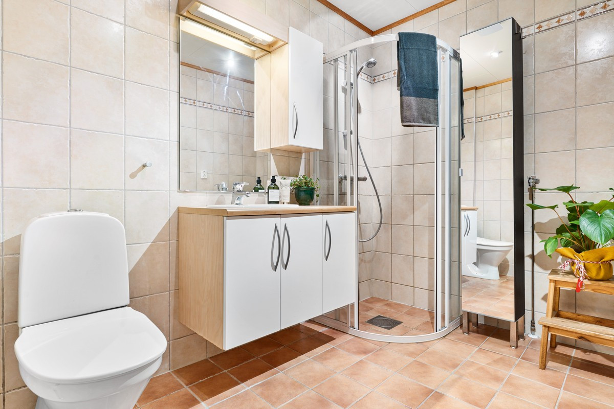 Badet er komplett flislagt med dusjhjørne og gulvstående toalett