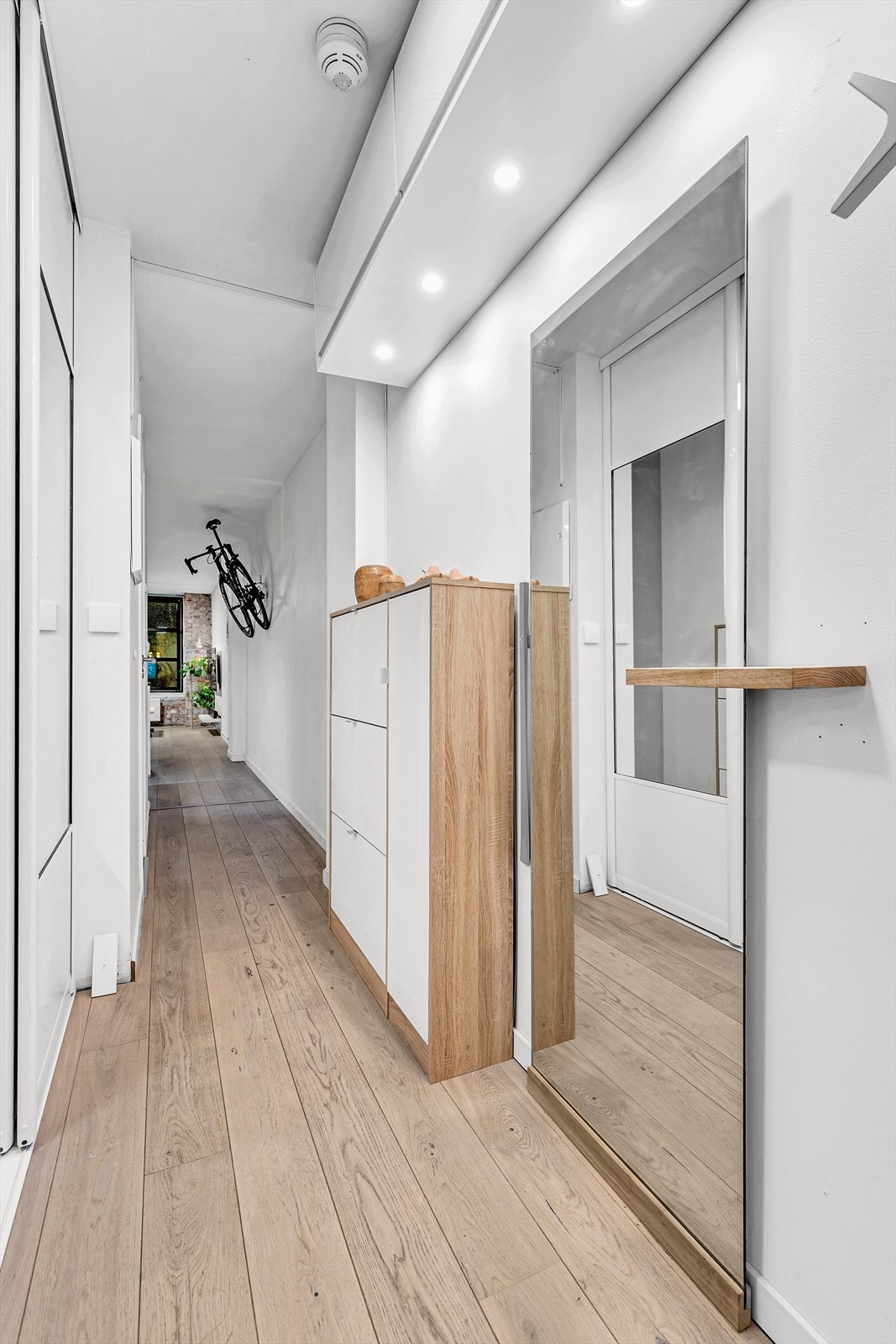 Entréen er lys og langstrakt med praktiske HTH skap montert oppunder himlingen. Med dør-calling slipper du gjestene enkelt inn fra bakkeplan. Galleribilde