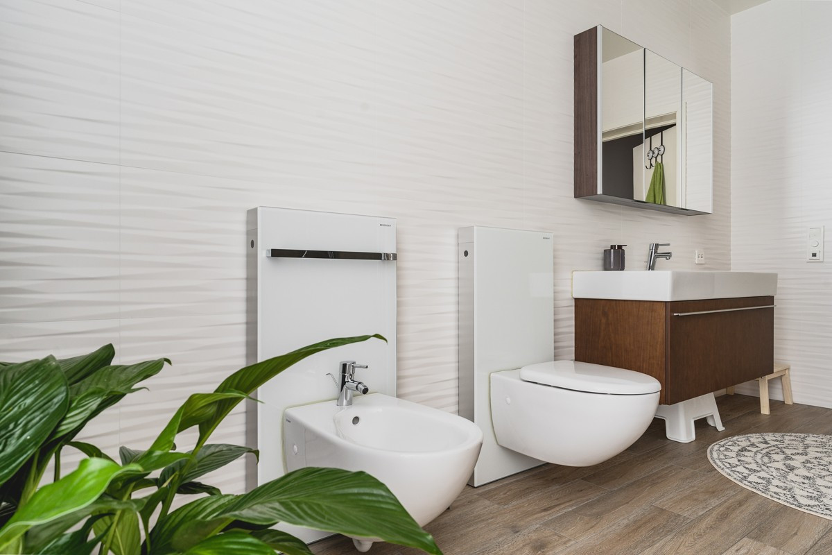 Badet er innredet med toalett, bidee, dusj, badekar og servant med skap og speil