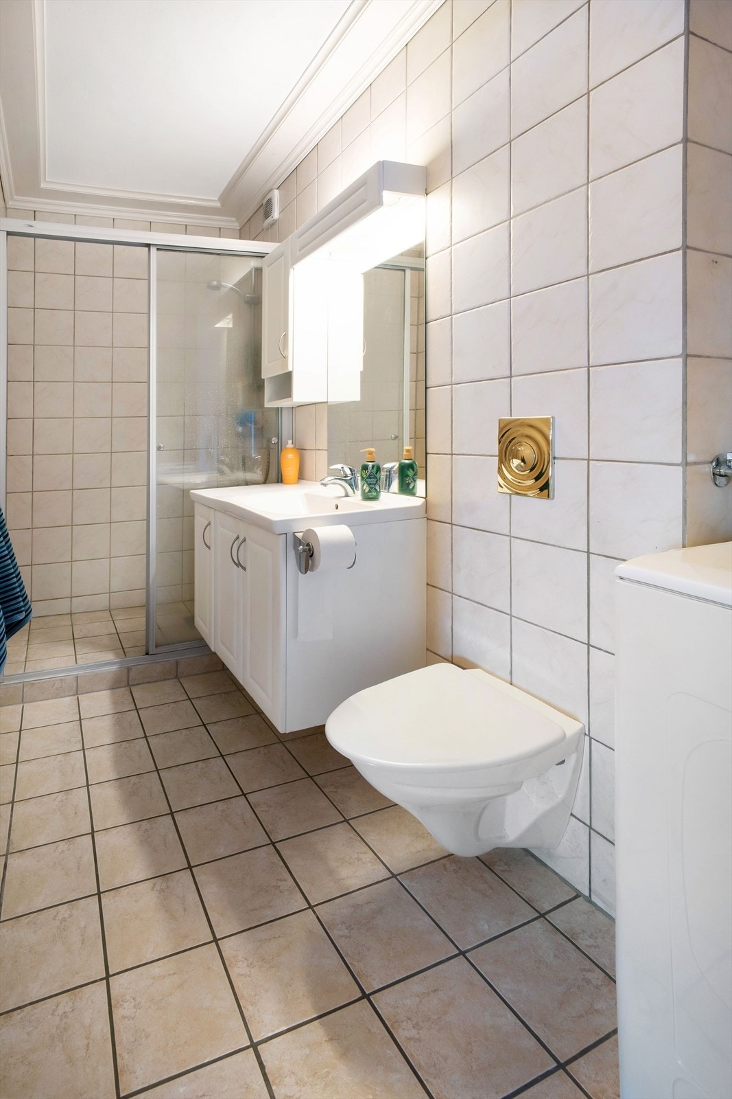 Pent flislagt bad med vegghengt wc, dusjnisje og opplegg for vaskemaskin Galleribilde