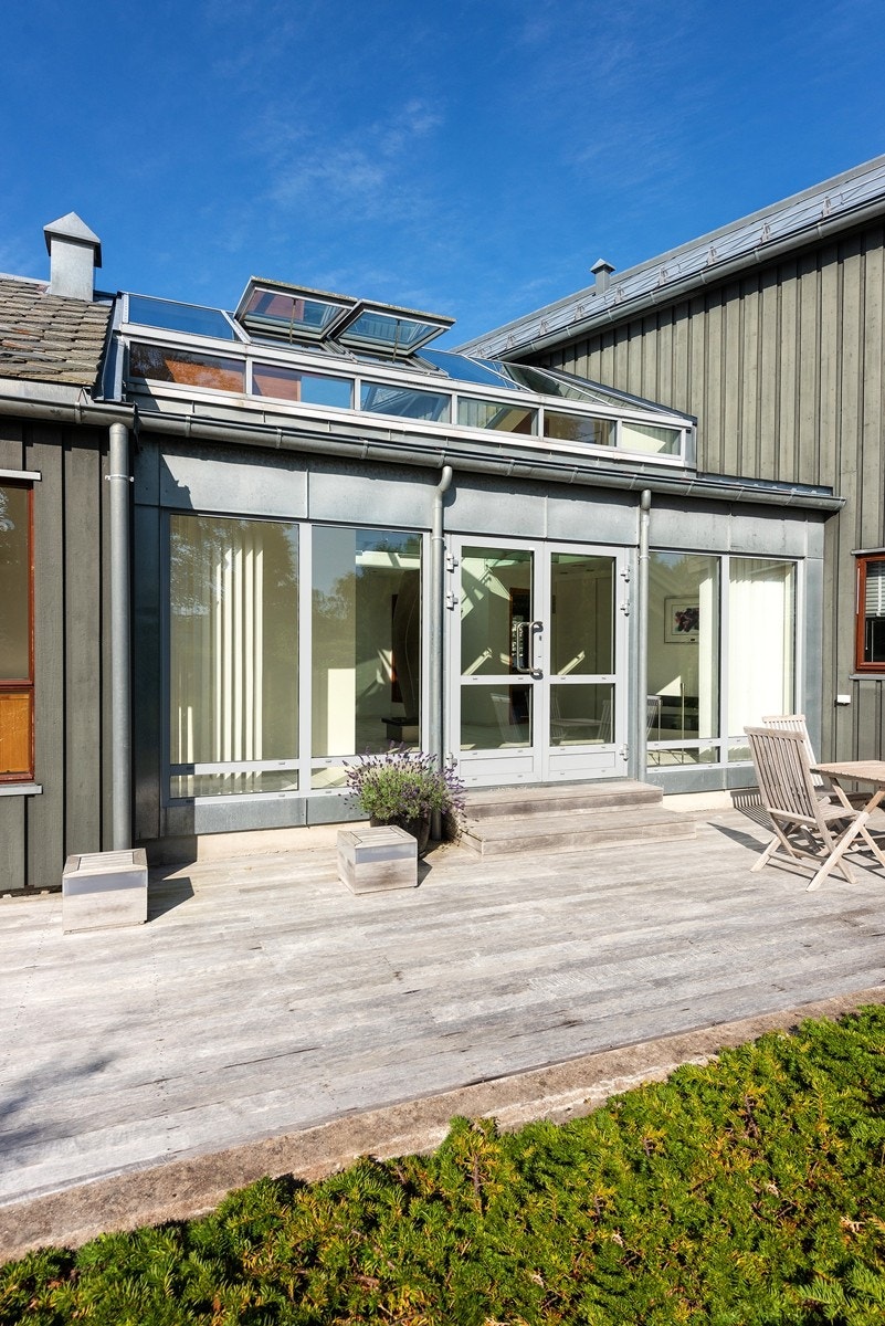 Utgang fra hall (atrium) i boligdelen til terrasse med teak tredekke Galleribilde
