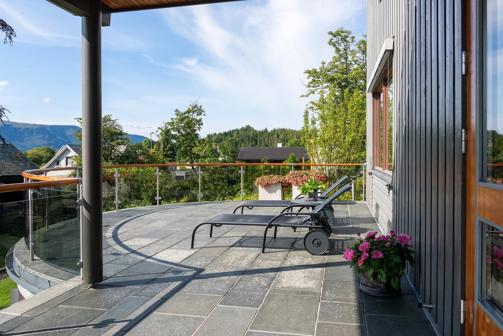 Sydvendt terrasse med skifer og glassrekkverk. Elektriske monterte aluminiumspersienner mot syd og vest Galleribilde