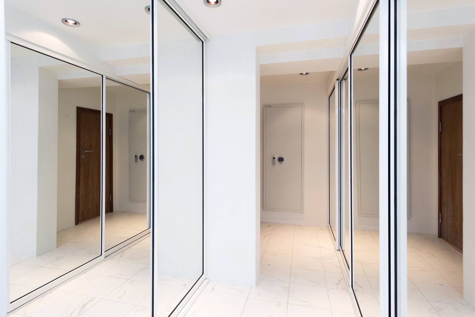 Gang med flislagt marmorgulv og skyvedørsgarderober i kjeller med brannsikker safe og teknisk rom Galleribilde