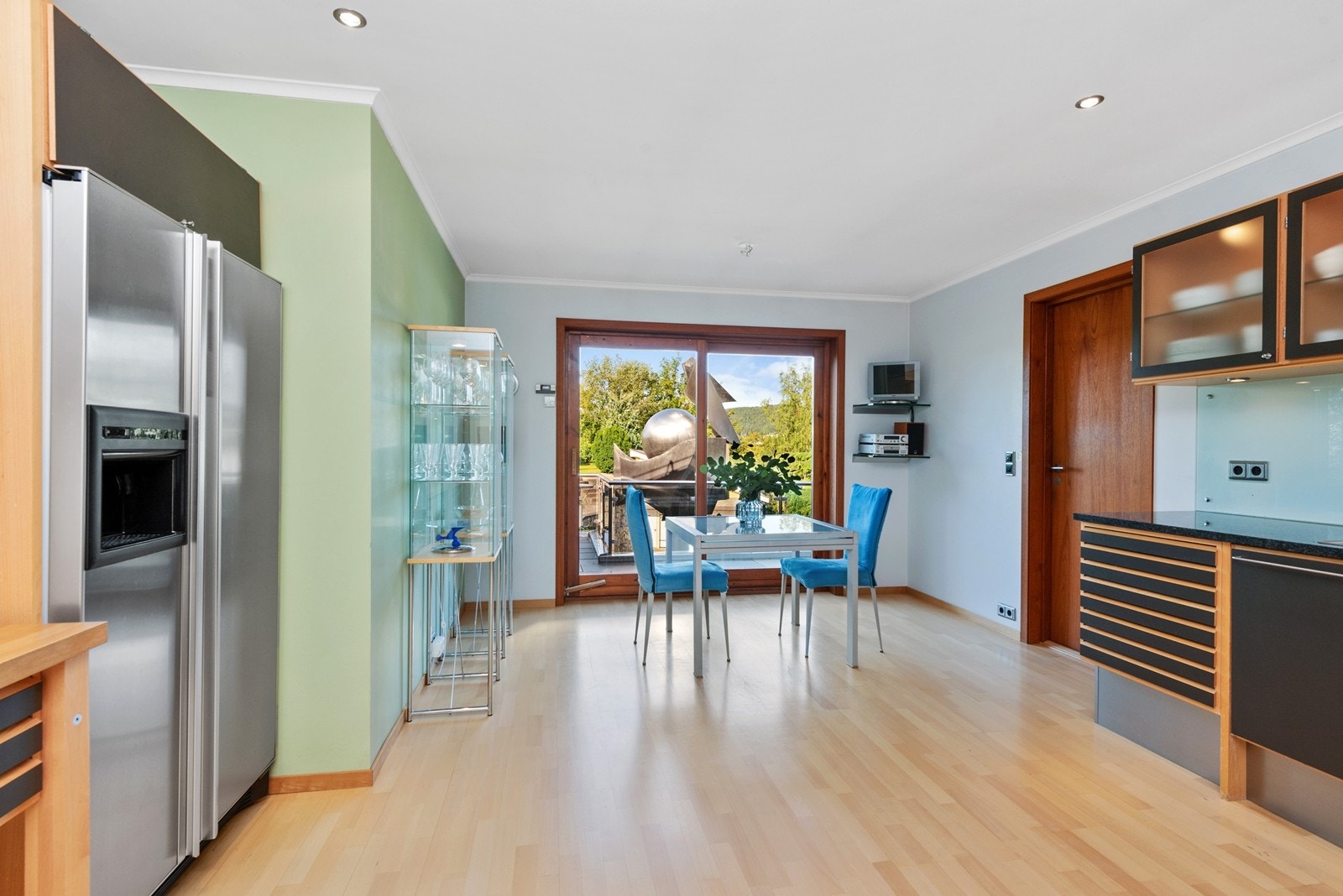 Kjøkken med spiseplass og skyvedør til terrasse mot vest Galleribilde