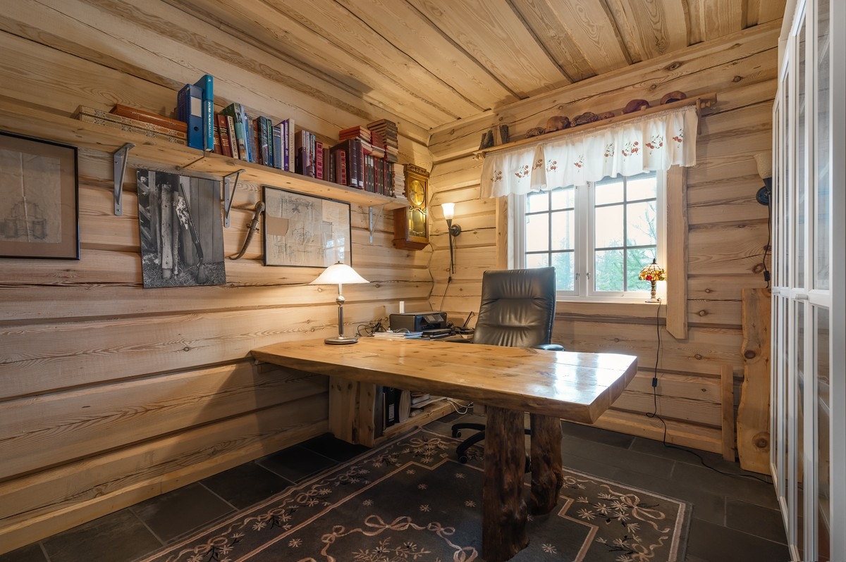 Boligen har et praktisk kontor i den nederste etasjen, som er innredet med veggmonterte hyller og en plassbygget kontorpult. Galleribilde