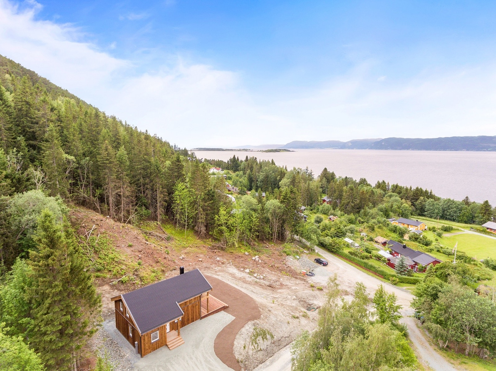 Tomta befinner seg nedenfor hytta på bildet. Galleribilde