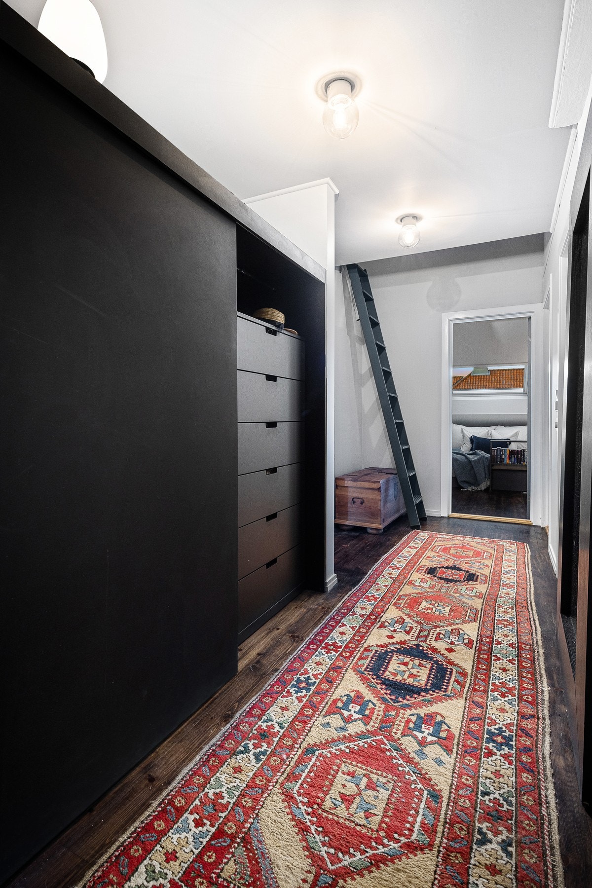 I entreen/gangen ryddes jakker og sko pent bort i garderobeløsningen i valkromat, tegnet av arkitekten Bodil Reinhardsen Galleribilde