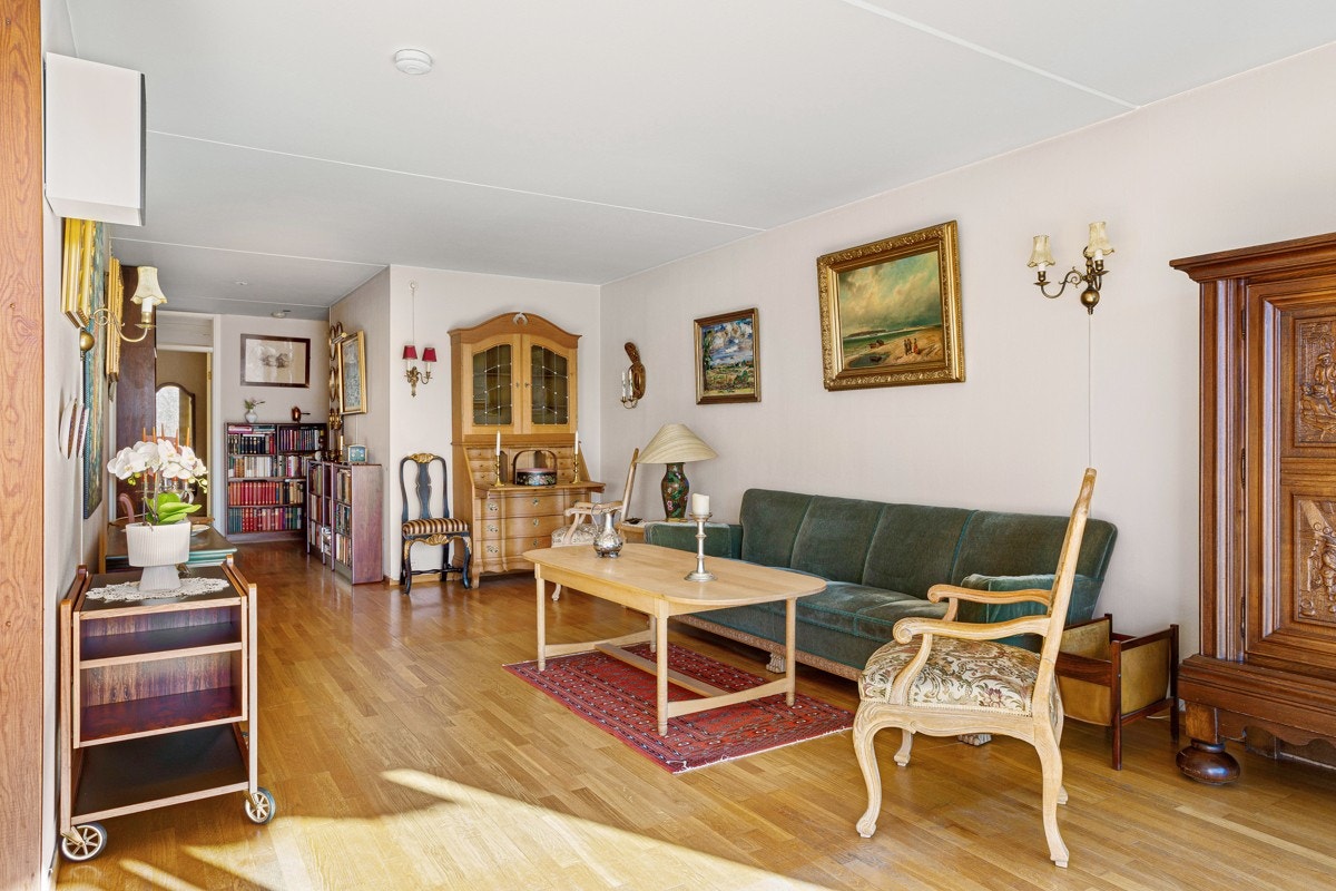 Stuen er et hyggelig rom med parkettgulv og strietapet. Galleribilde