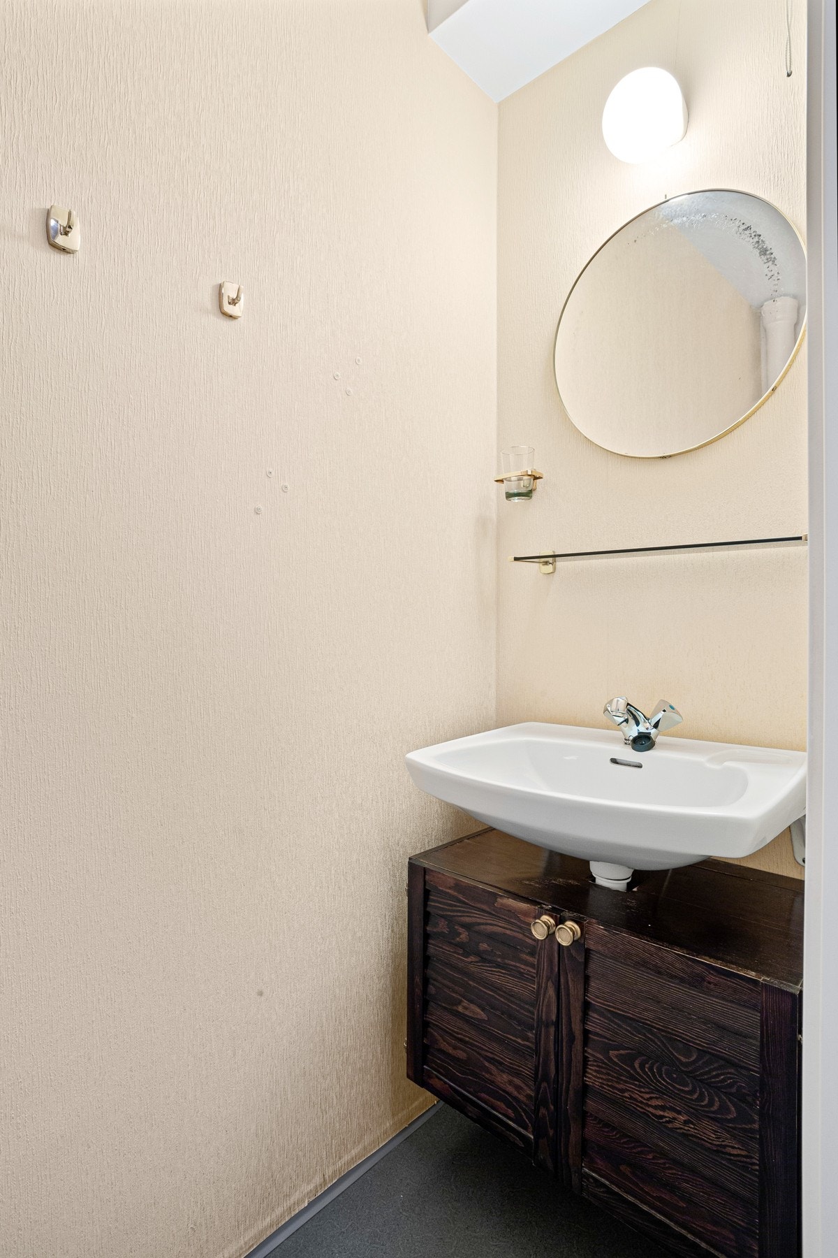 Toalettrommet har toalett, servant med skap i underkant, vegghylle, og belysning over speil. Galleribilde