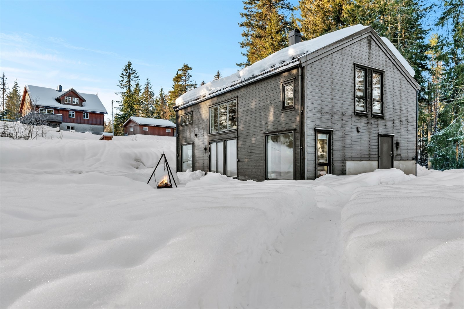 Tomten er opparbeidet med noe plen og gruset oppkjørsel. Ellers i all hovedsak stedegen vegetasjon. Galleribilde