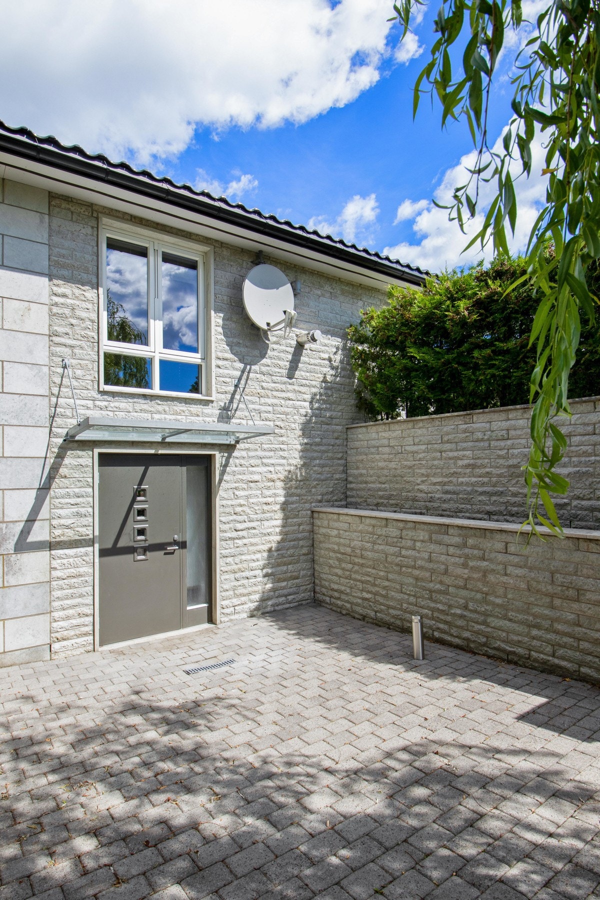 Rommet har utgang til hagen og en steinsatt gangbane som fører bort til tennisbanen og skateparken. Galleribilde