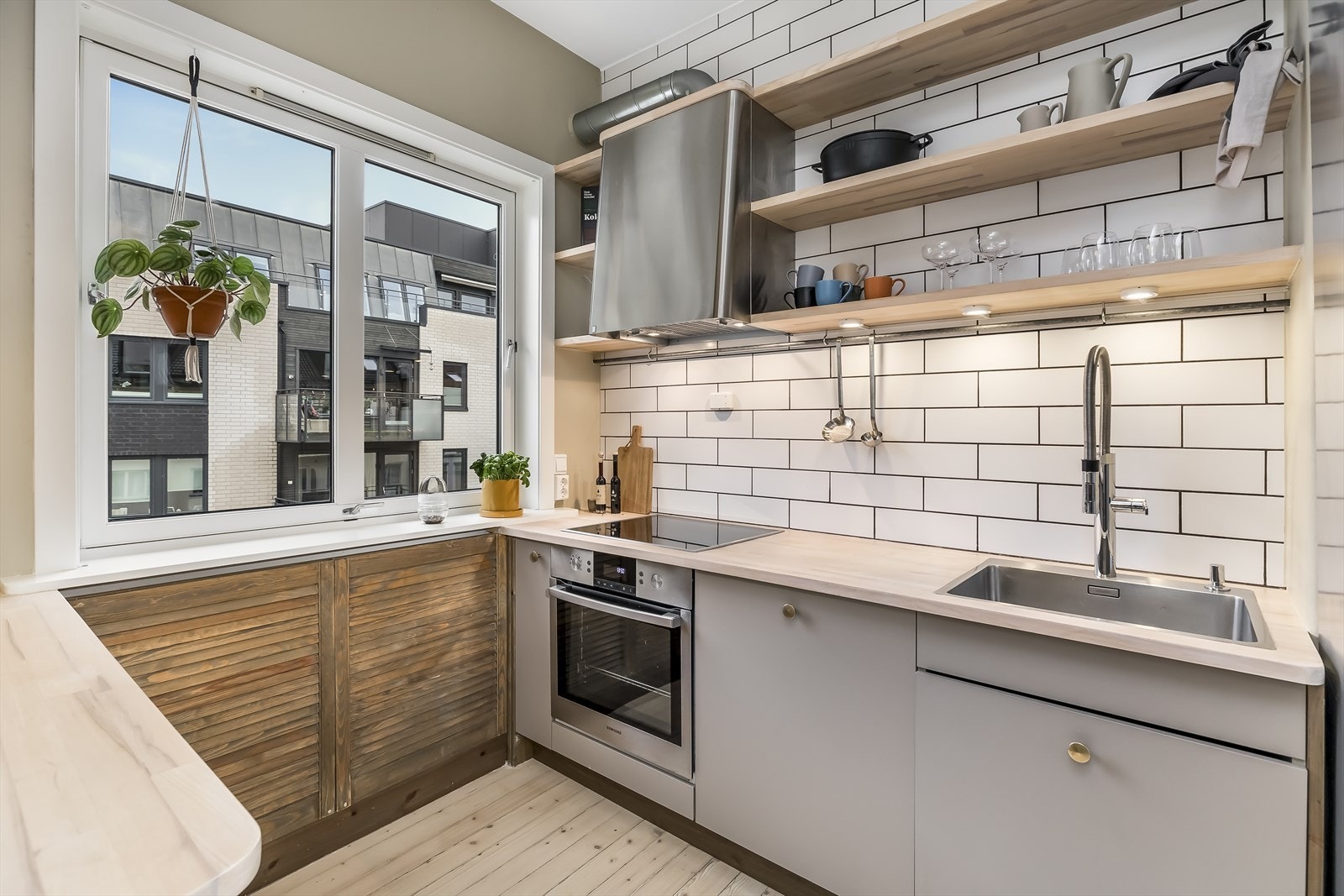 Moderne HTH kjøkkeninnredning, eksklusiv Røroshetta ventilator, blandet med den originale sjarmen gir et spennende kjøkken Galleribilde