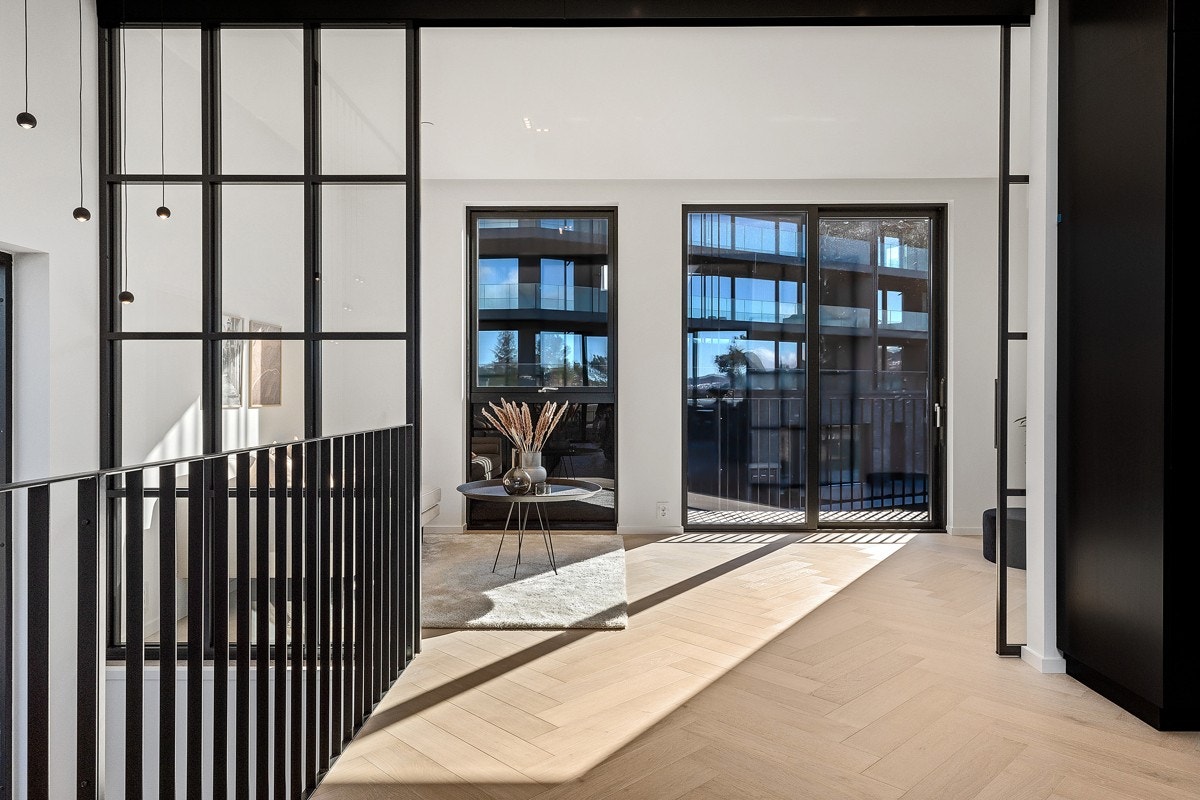 TV-stuen kan lukkes igjen og skilles fra stue/kjøkken med en lekker skyvedør i smijern Galleribilde