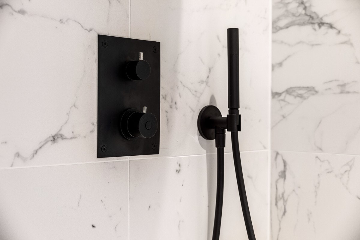 Dusj har rørene bygget inn i veggen, med sorte eksklusive detaljer Galleribilde