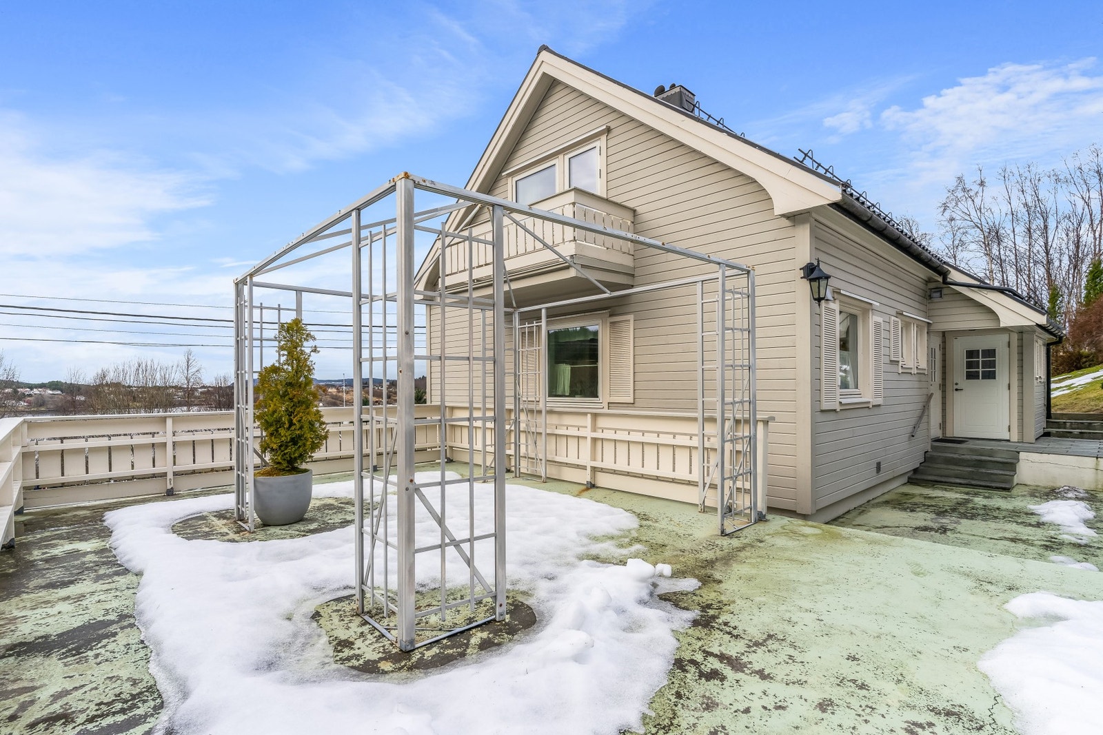 Stor terrasse over garasje dekke av betong og med rekkverk i trekonstruksjon. Galleribilde