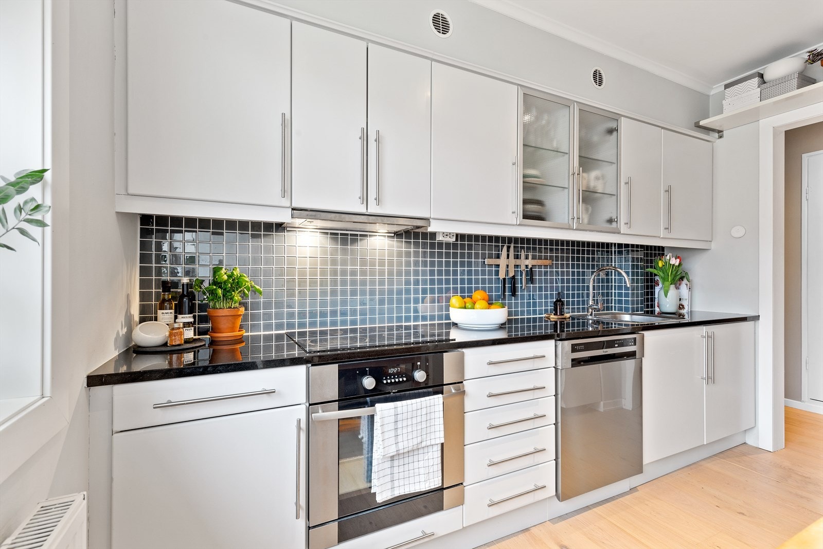 Det er pent fliselagt mellom overskap og benkeplate. Galleribilde