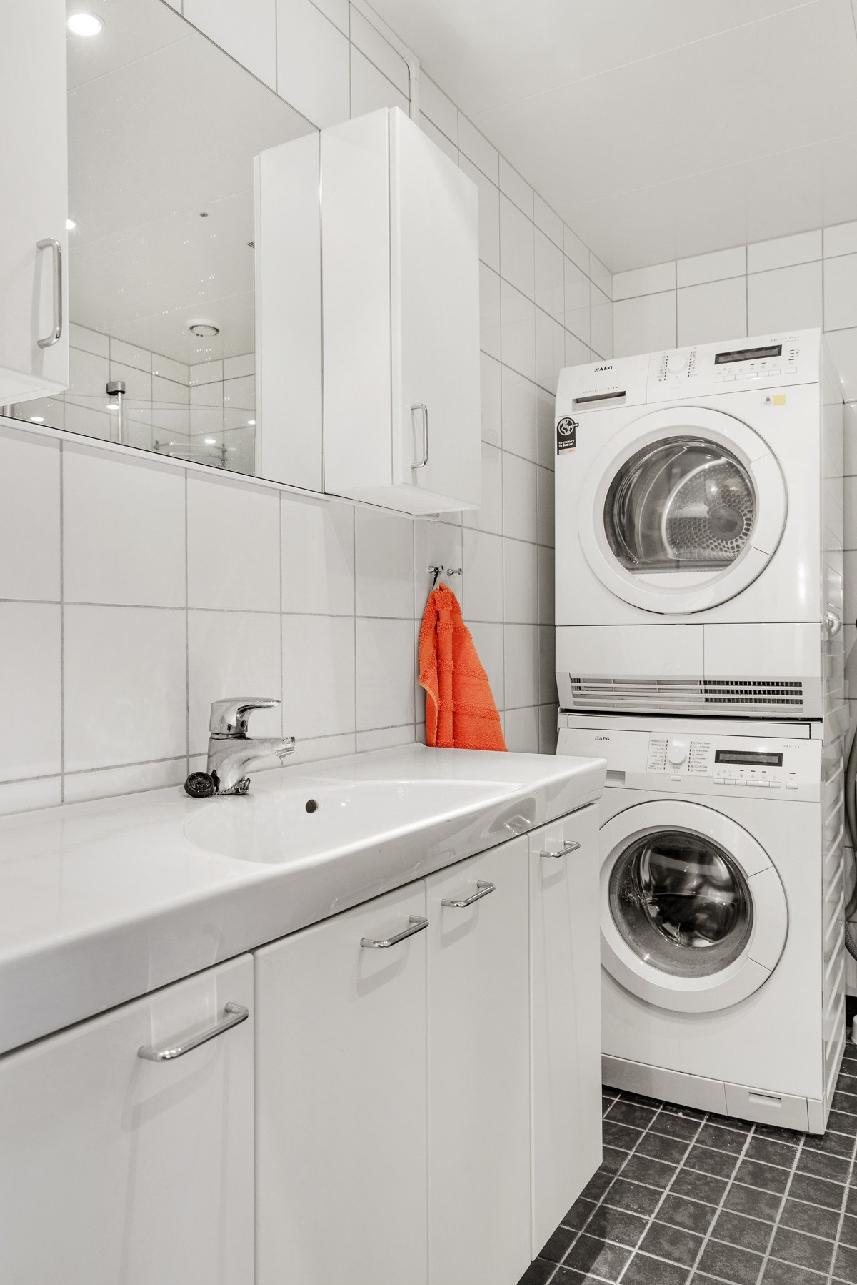 Stort og delikat flislagt baderom med gulvvarme med plass til vaskemaskin og tørketrommel Galleribilde