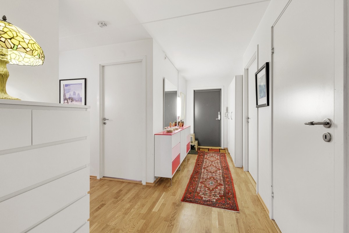 Innbydende og romslig entré med god plass til å henge opp yttertøy å sette fra seg sko. Fra entréen er det inngang til boligens øvrige rom. Dørcalling med åpner. Galleribilde