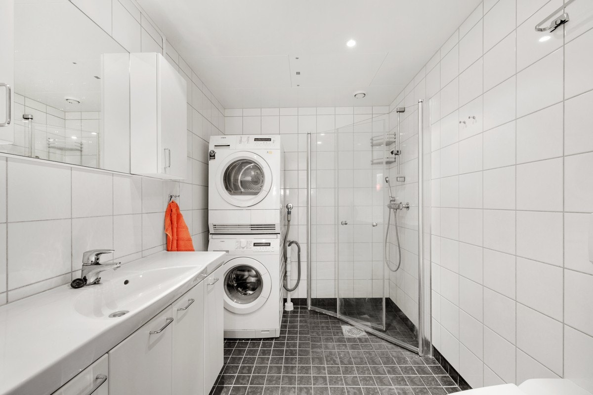 Stort og delikat flislagt baderom med gulvvarme med plass til vaskemaskin og tørketrommel. Galleribilde