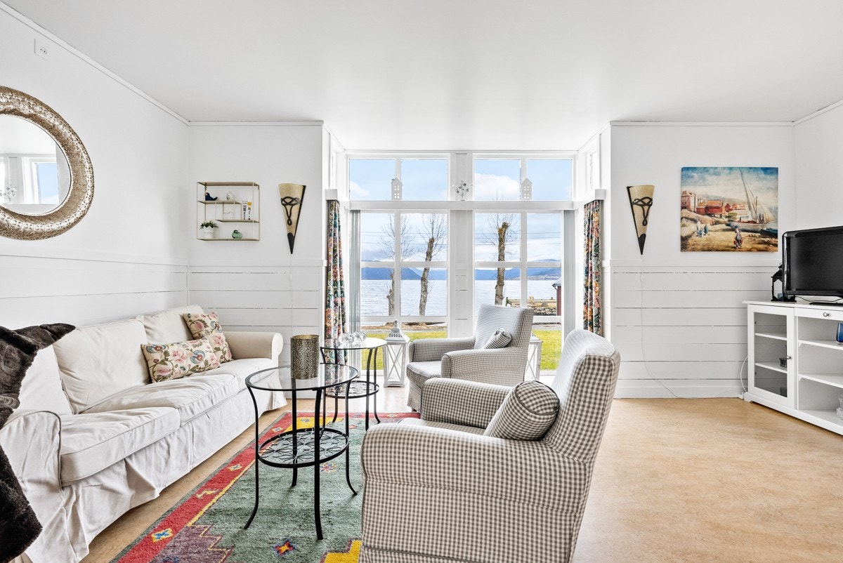 Stue med store vindu som vender mot hagen og videre med utsikt over fjorden Galleribilde