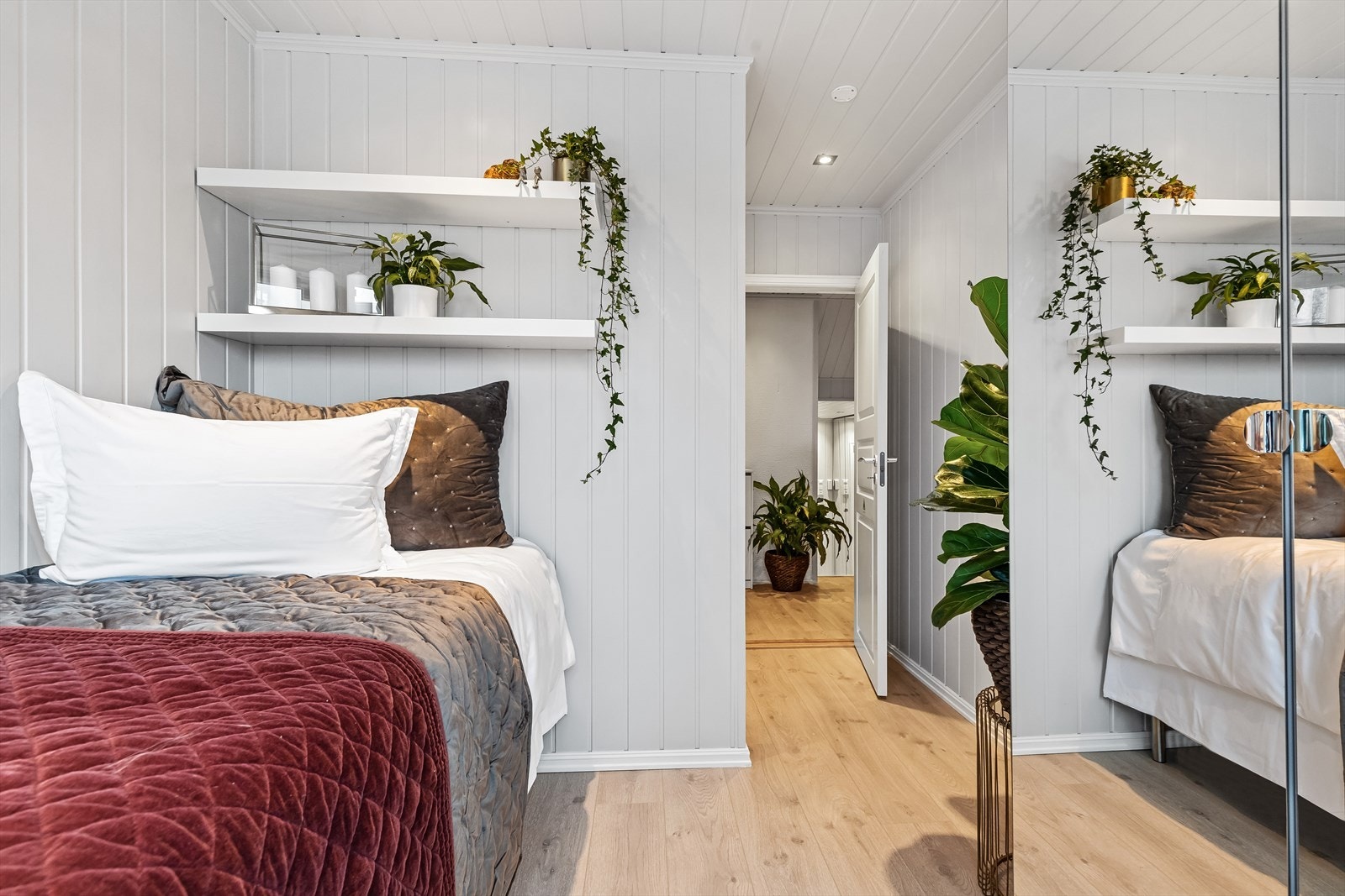 Videre er rommet innredet med garderobeskap med speilfronter. Galleribilde