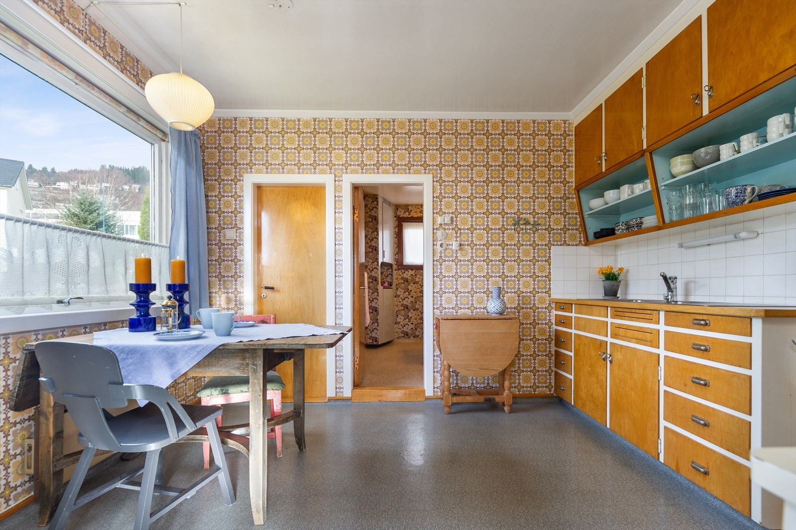 Stilig, retrokjøkken med skråstilte overskap/hyller. Bad og spiskammers i tilknytning. Galleribilde