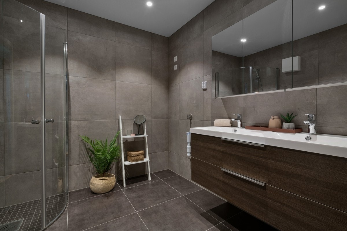 Badet er virkelig lekkert med store, stilige vegg- og gulvfliser i like gråtoner. Galleribilde