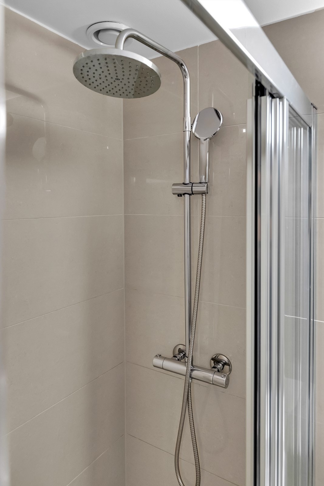 Badet er innredet med dusjhjørne med skyvedører og bunnlist, servantskap med ett-greps blandebatteri, speil på vegg og gulvstående toalett. Galleribilde