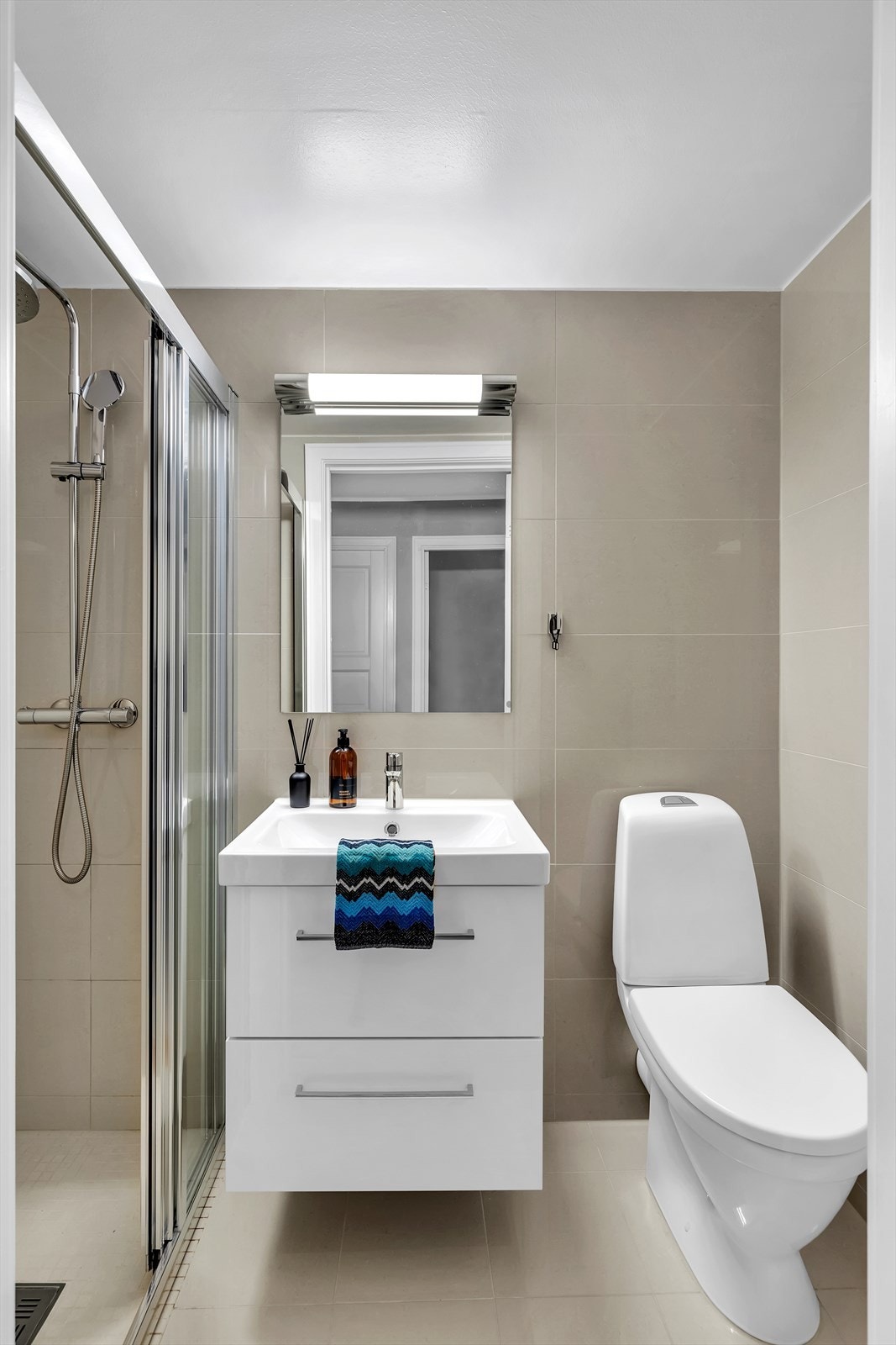 Pent bad som ble overflate oppusset i 2018, med flislagt gulv med nedsenk i dusjsonen. Galleribilde