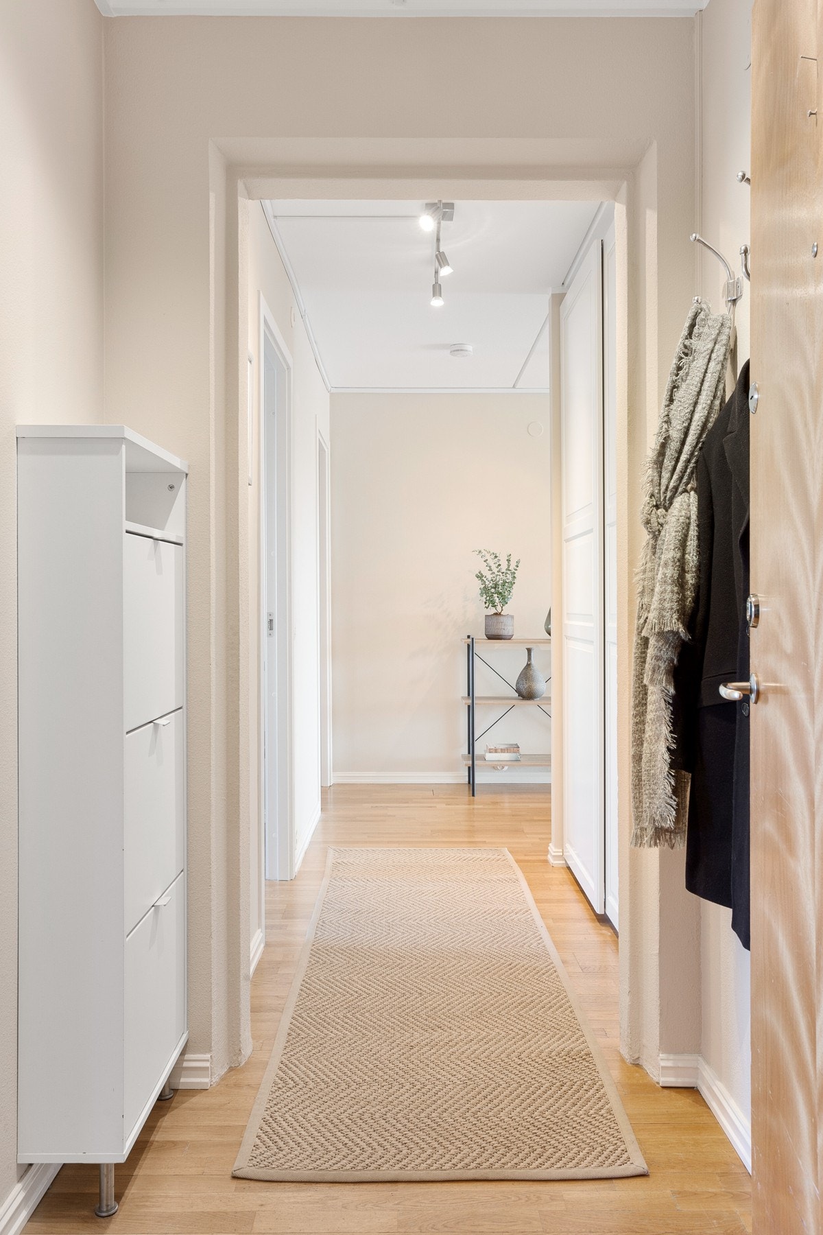 I ytre del av entreen finnes det dørcalling med monitor, hvitt skoskap og åpen garderobeløsning. Galleribilde