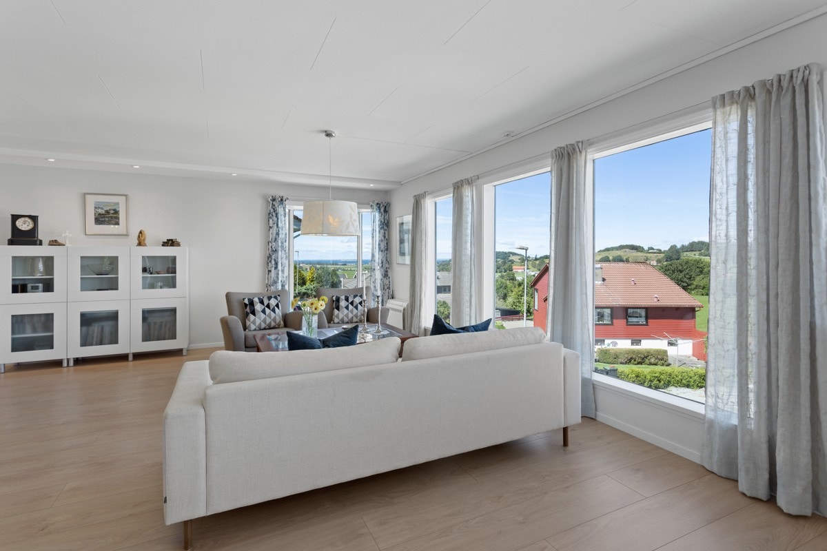 Den lyse og hyggelige stuen har god plass, og utgang til en fin uteplass. Galleribilde