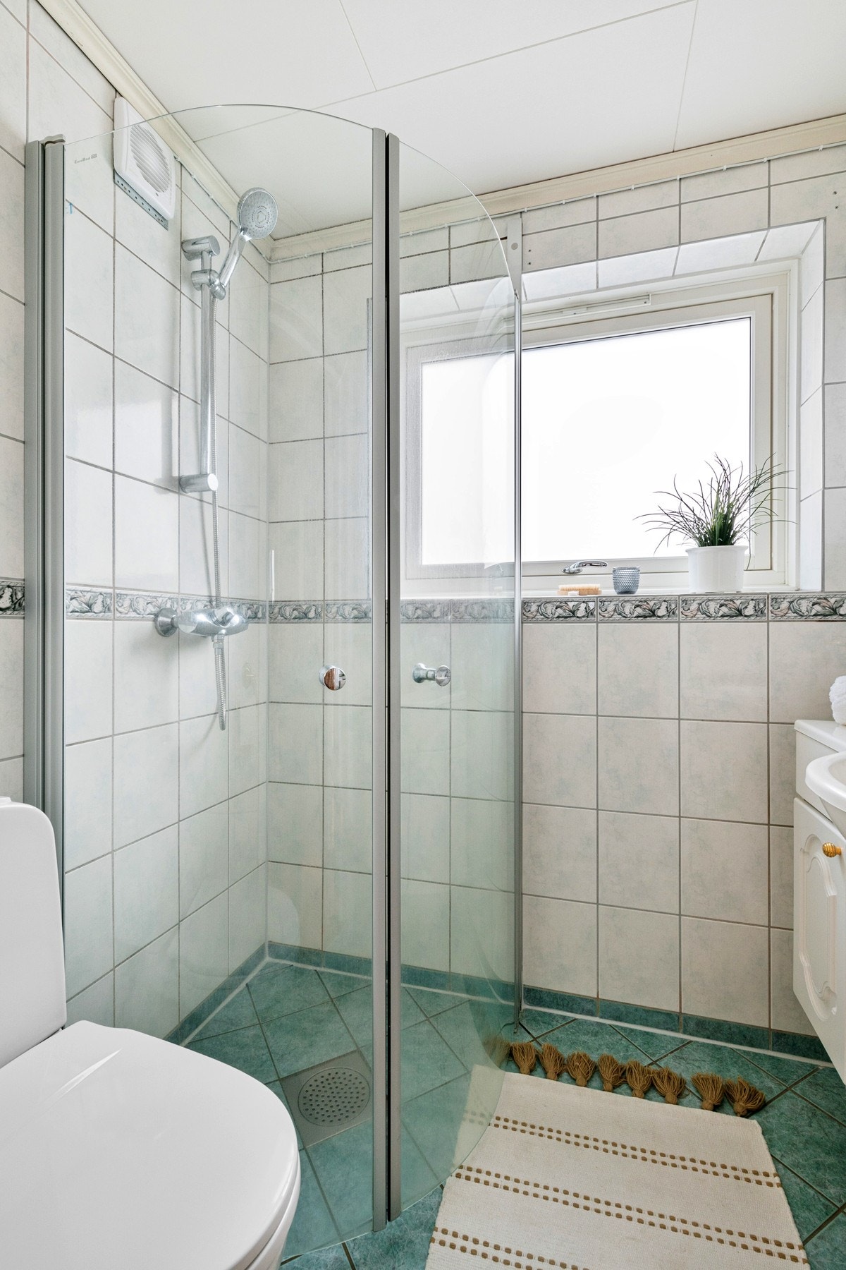 Det ble gjort noe arbeid på badet i ca. 2015, og rommet har grønne gulvfliser med gulvvarme til lysere veggfliser med noe dekor. Galleribilde