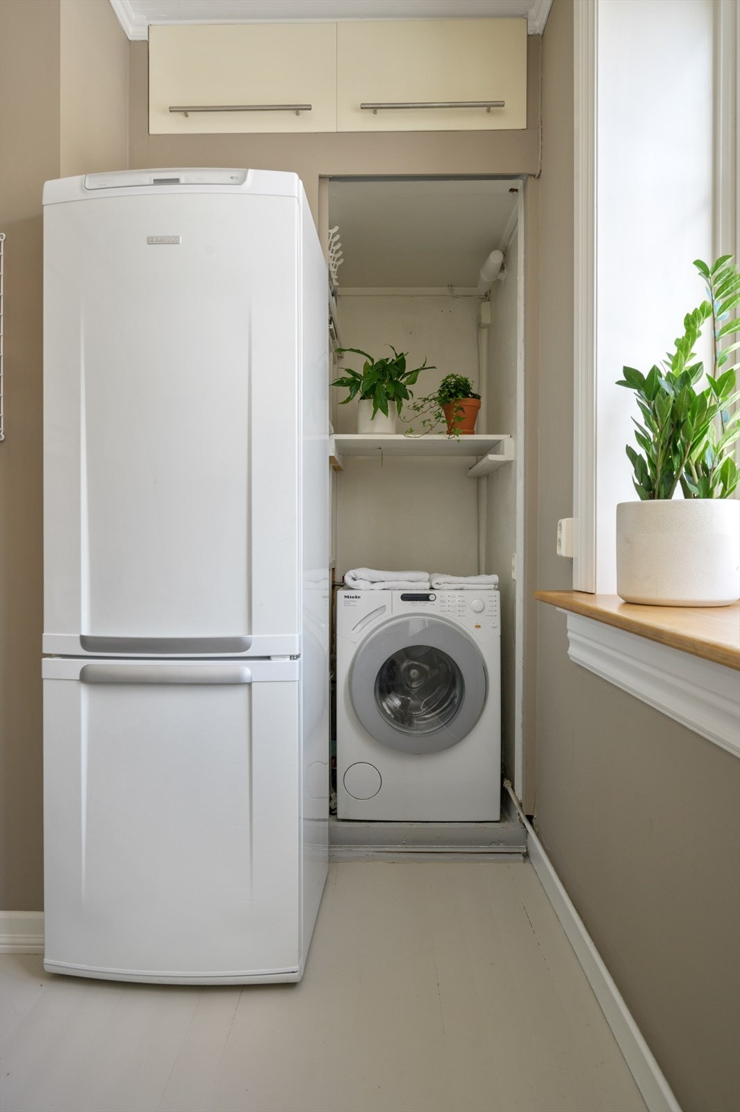 Det er opplegg for vaskemaskin i et praktisk skap på kjøkkenet. Galleribilde