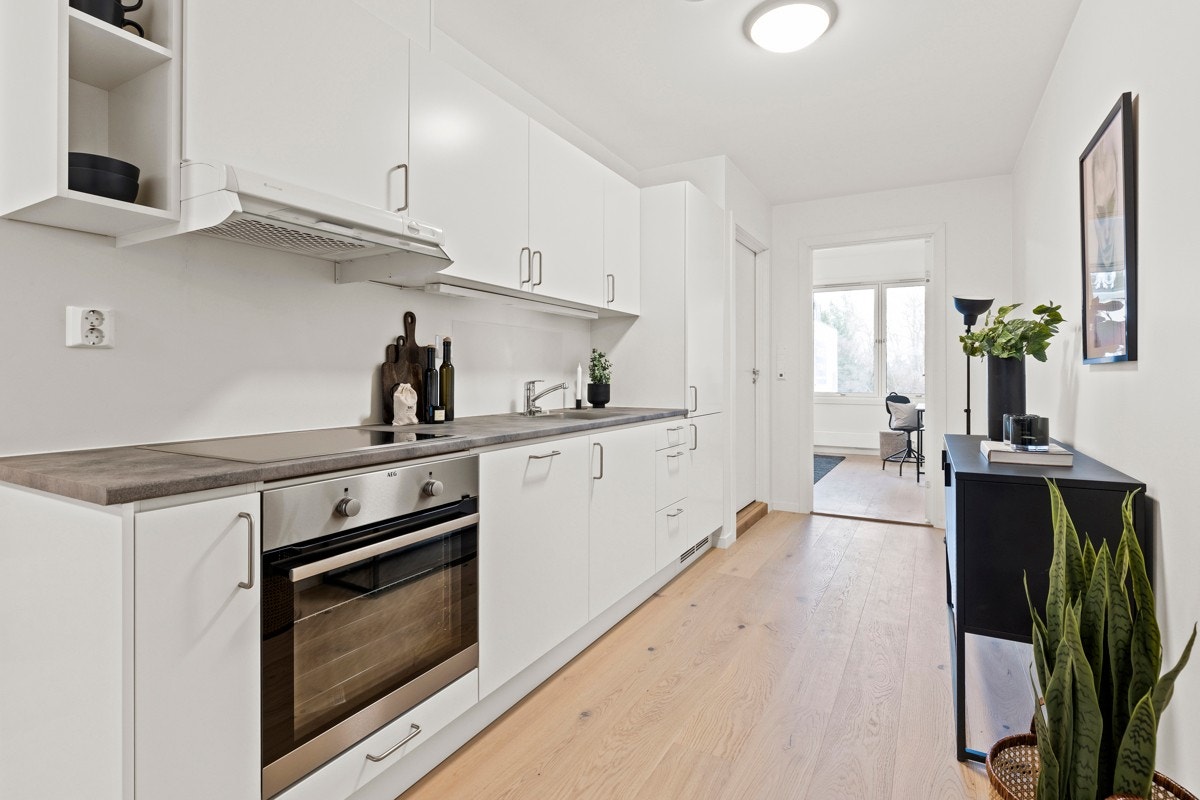 Kjøkkenet er av lyse slette fronter, med smart planløsning for å utnytte mest mulig av leiligheten. Galleribilde