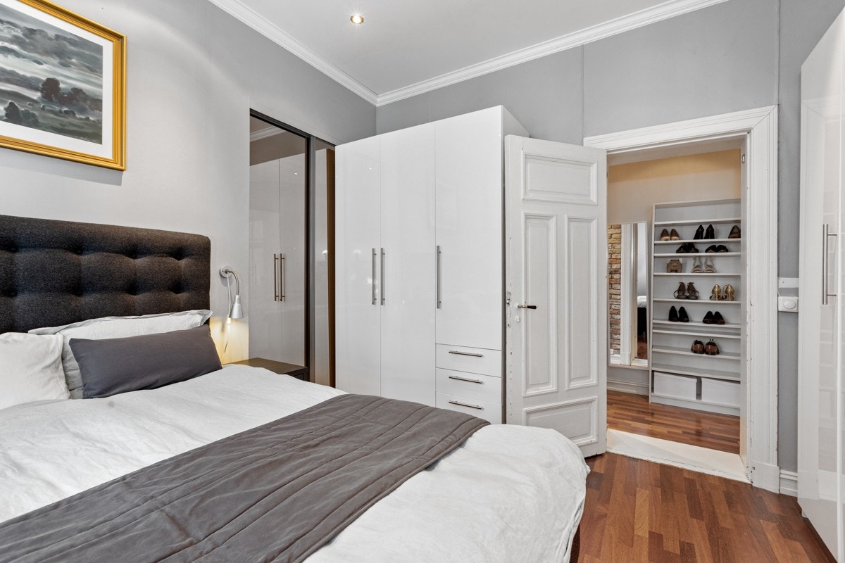 Her er det godt med plass til en stor dobbeltseng og nattbord. Det er også er plass til store garderobeskap som følger med boligen, samt et ekstra garderoberom i hjørnet med god plass til lagring. Galleribilde