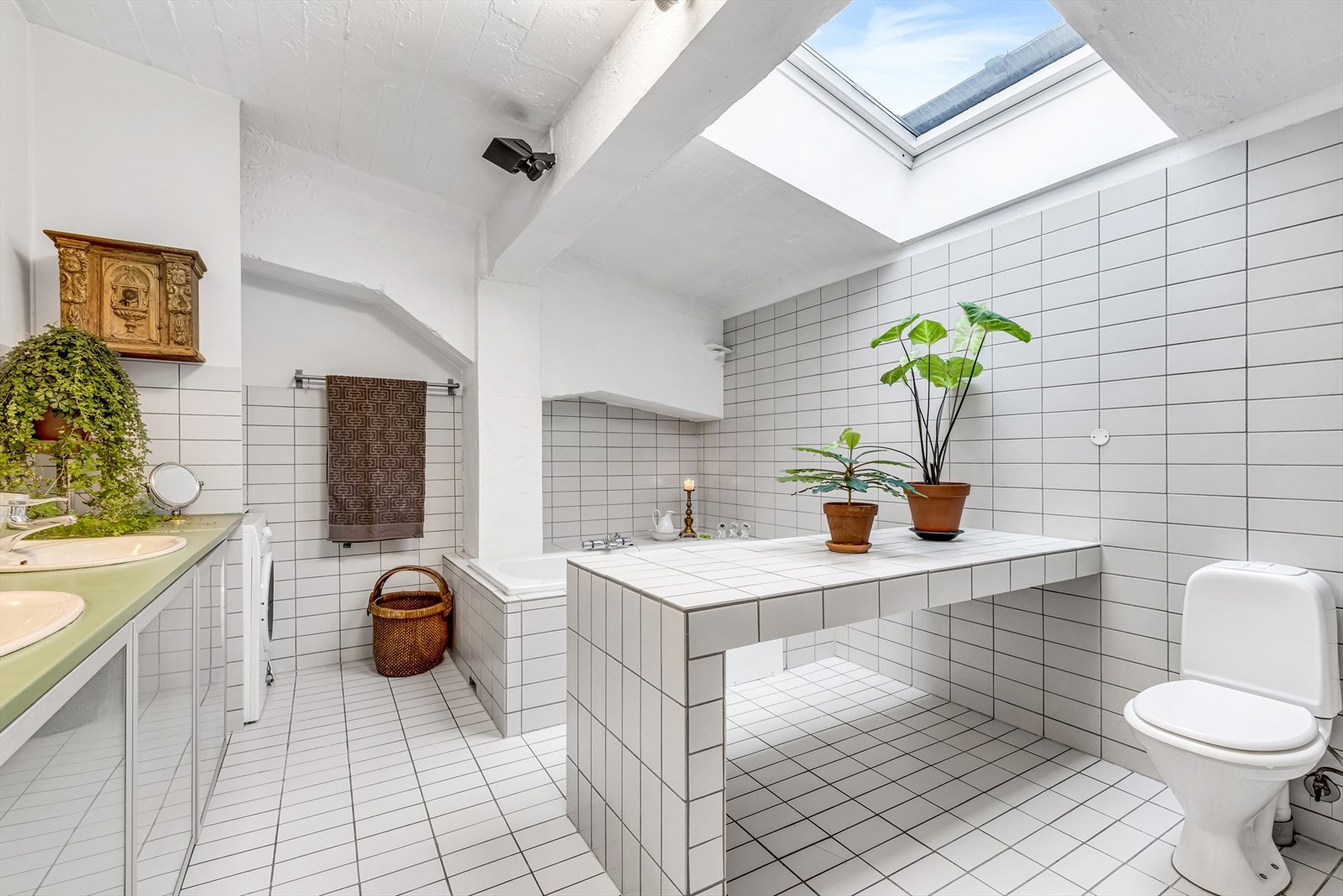 Flislagt baderom med dusjhjørne, toalett, dobbeltservant, samt vaskemaskin. Dagens eier har satt inn en flislagt massasjebenk m/varmekabler. Galleribilde