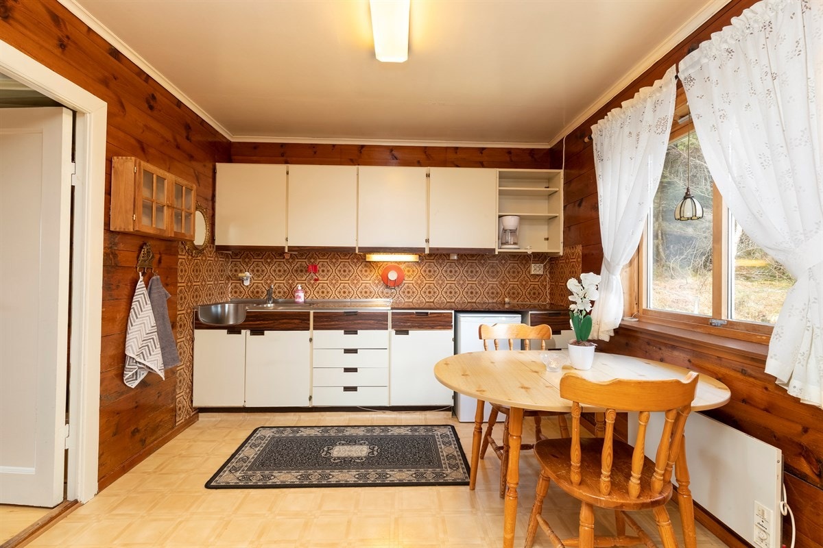 Kjøkkeninnredning med over- og underskap, benkeplate i laminat og frittstående hvitevarer Galleribilde