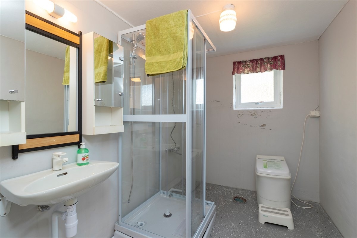 Bad i underetasjen med nyere dusjkabinett og forbrenningstoalett Galleribilde