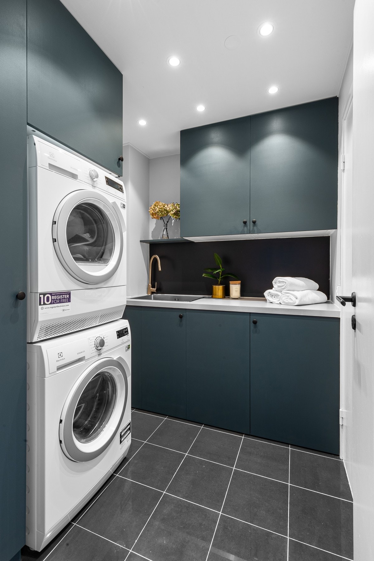 Det praktiske vaskerommet har benkeseksjon og nedfelt skyllekum i lys laminatbenkeplate. Galleribilde